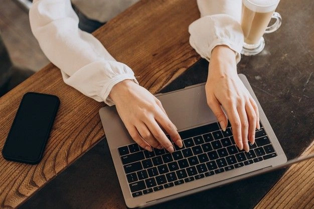 typing "how can you increase website traffic organically" on a laptop